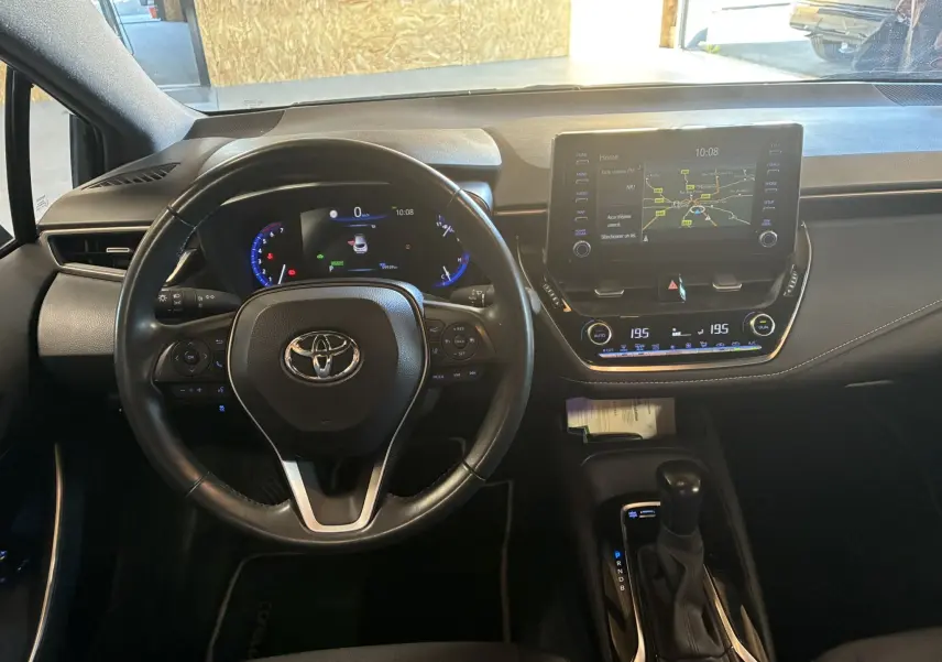 Vue intérieure du tableau de bord et volant cuir noir de la Toyota Corolla 1.8 122 Dynamic avec écran tactile et boîte auto.