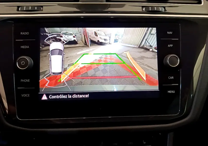 Écran tactile intérieur du Volkswagen Tiguan 2021 montrant la caméra de recul avec alertes de distance en mode stationnement.