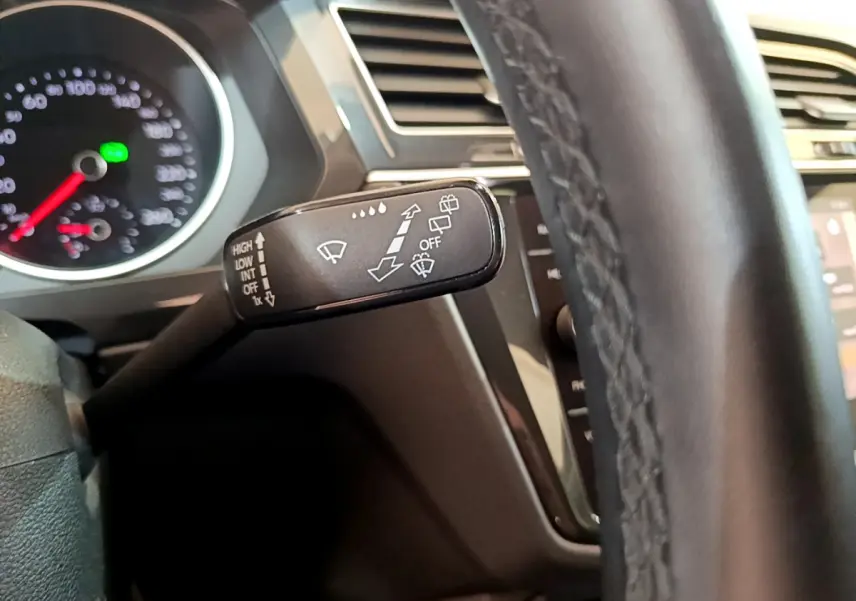 Gros plan sur la commande d’essuie-glace noire côté gauche du volant cuir du Volkswagen Tiguan gris clair 2021.