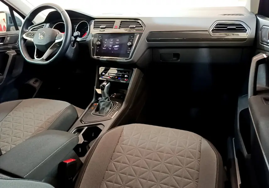 Vue intérieure avant du Volkswagen Tiguan 2.0 TDI 2021, montrant le tableau de bord et les sièges gris avec console centrale.