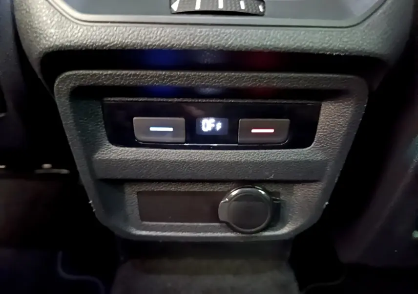 Vue rapprochée du panneau de commande de climatisation arrière noir avec affichage digital dans un Volkswagen Tiguan gris clair.