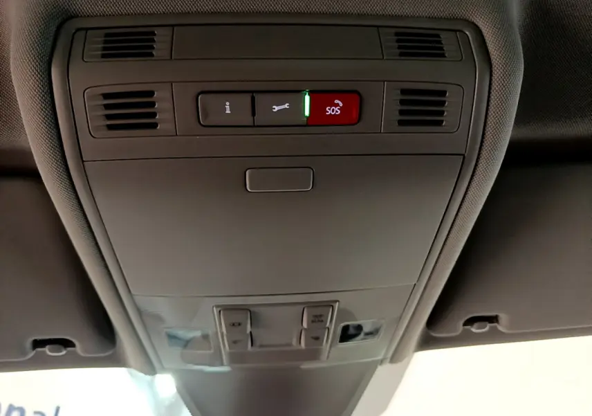 Vue en contre-plongée du panneau de commandes au plafond intérieur gris du Volkswagen Tiguan 2021 avec bouton SOS rouge allumé.