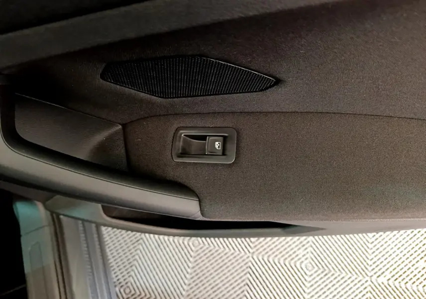 Détail de la poignée intérieure de porte arrière droite du Volkswagen Tiguan gris clair 2021.