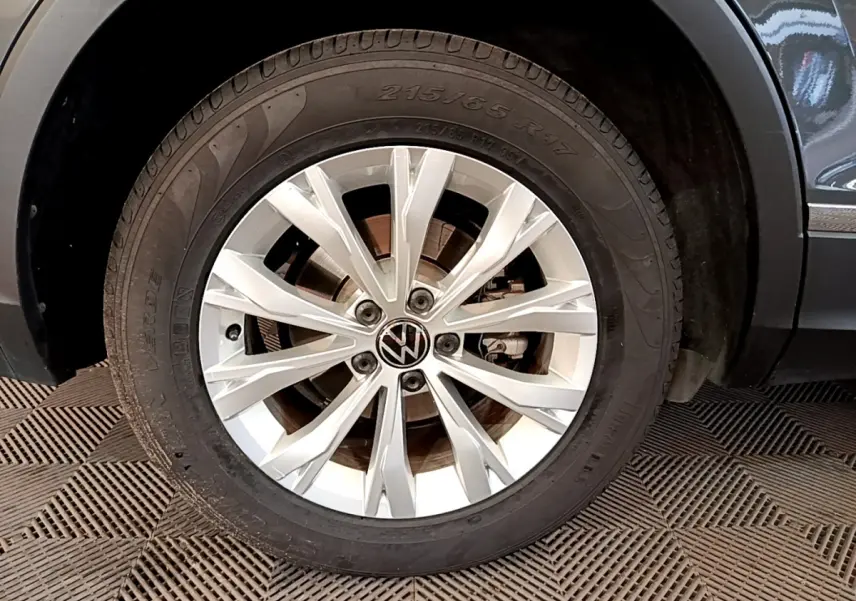 Gros plan sur la roue avant droite gris clair du Volkswagen Tiguan 2.0 TDI avec jante alliage à 10 branches.