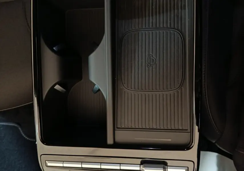 Vue plongeante sur la console centrale noire du Hyundai Tucson 2025 avec zone de recharge sans fil et commandes tactiles.