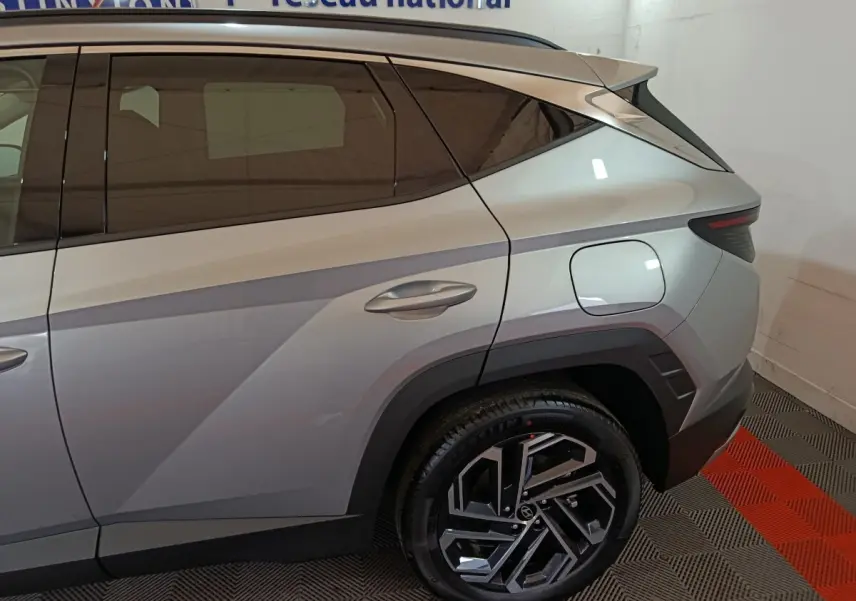 Vue latérale arrière droite du Hyundai Tucson gris clair 2025 avec jante alliage au design moderne et feux arrière LED.