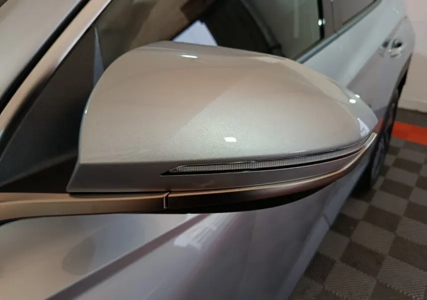 Gros plan sur le rétroviseur droit gris clair du Hyundai Tucson 2025, avec clignotant intégré, vue latérale.