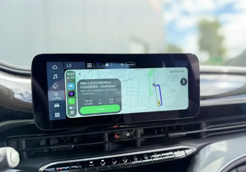 Vue rapprochée de l'écran tactile central du tableau de bord de la FIAT 500 électrique blanche, affichant la navigation GPS.