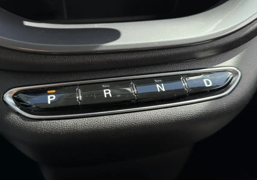 Gros plan sur la commande de boîte automatique noire avec boutons P, R, N, D dans une Fiat 500 électrique 2024.