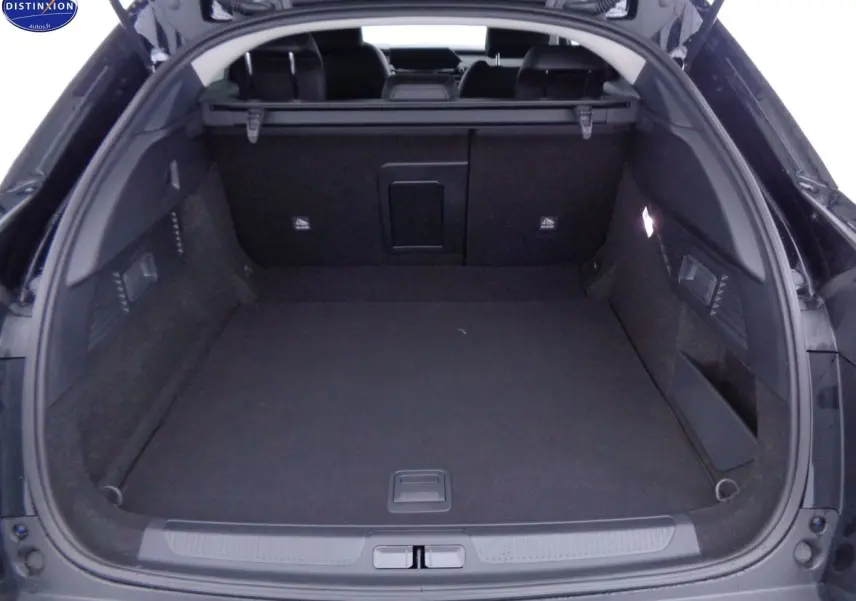 Coffre ouvert vu de l'arrière d'une Citroën C5 X noir métal, montrant un espace de chargement spacieux et bien fini.