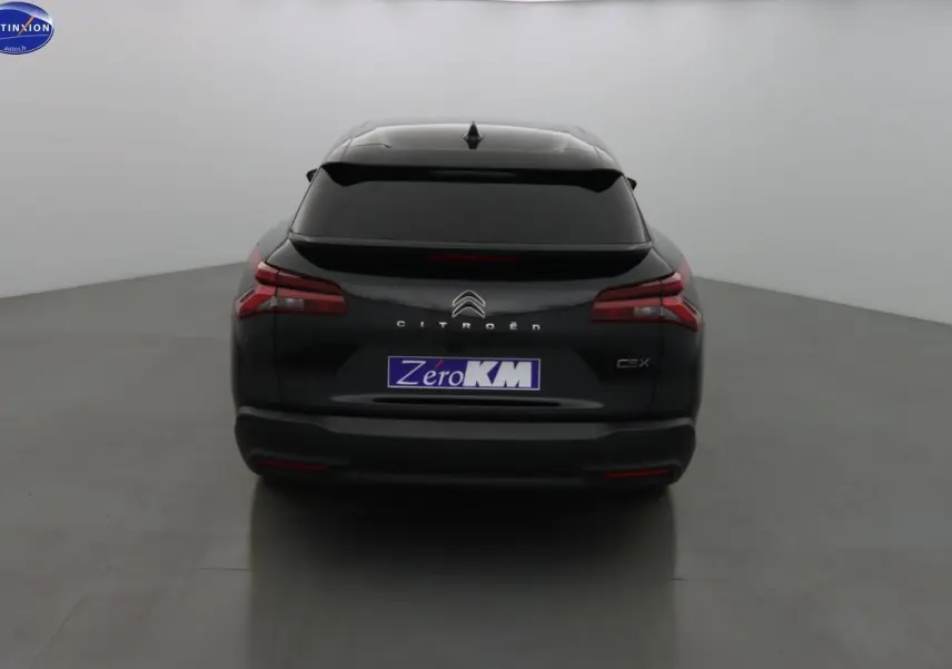 Vue arrière d'une Citroën C5 X noire métal avec feux LED et lunette arrière teintée dans un studio.