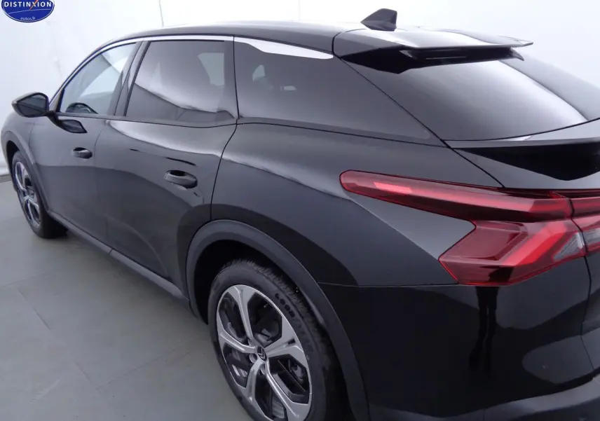 Vue 3/4 arrière droite d'une Citroën C5 X noire métal avec feux arrière LED et jantes bi-ton.