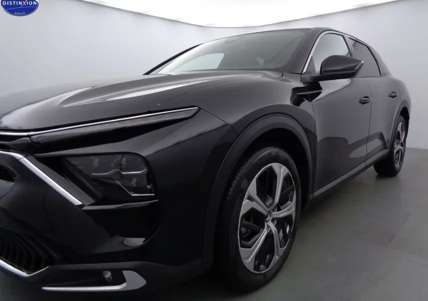 Vue 3/4 avant droit d'une Citroën C5 X noire métal avec phares LED et jantes bi-ton distinctives.