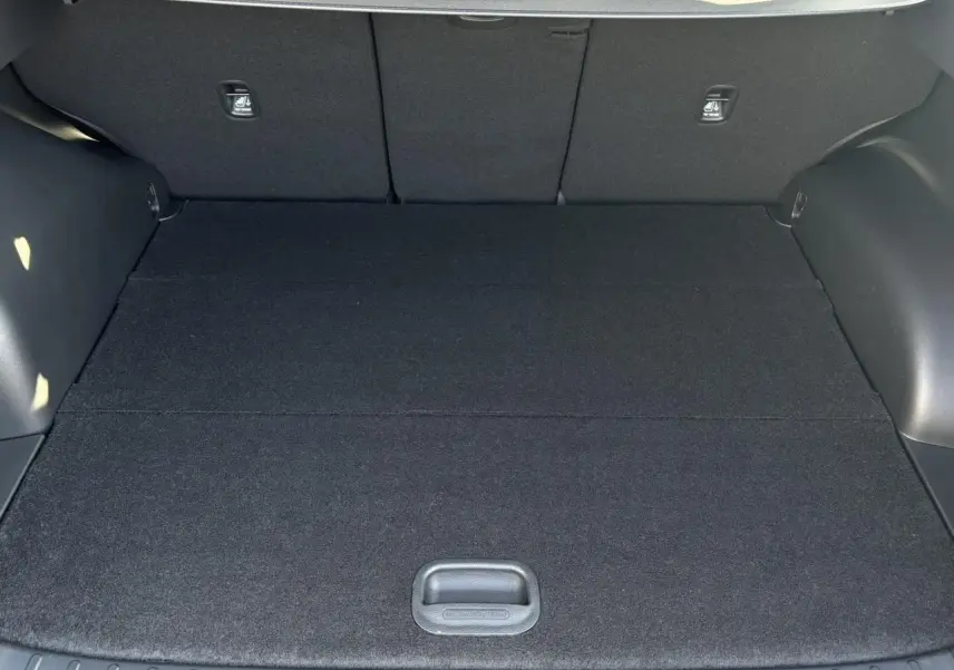 Coffre ouvert vu de l'intérieur d'un Hyundai Tucson Cypress Green 2025, espace de chargement plat et noir.