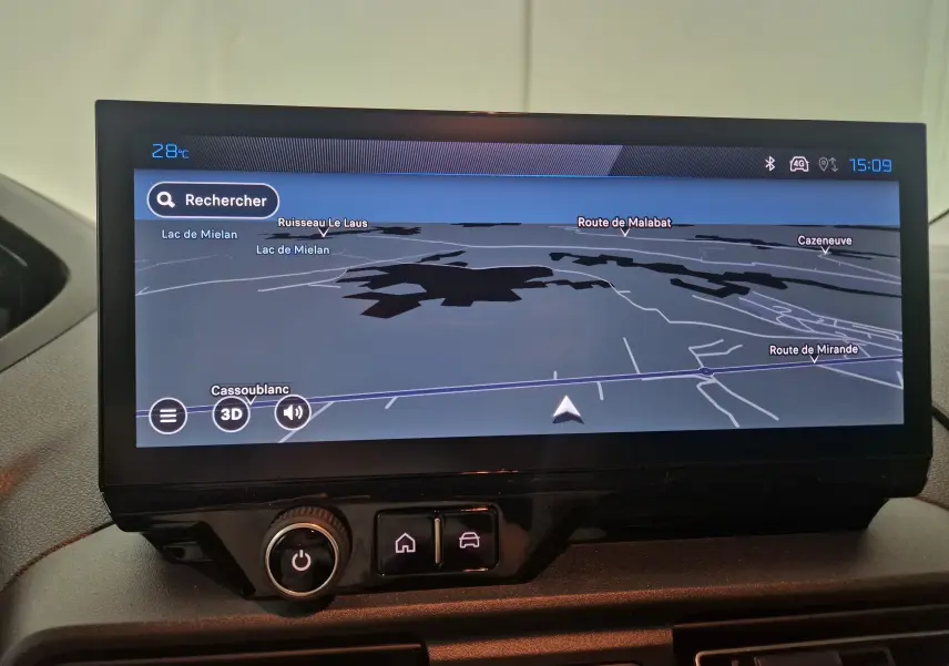 Écran tactile du système de navigation du Peugeot Partner blanc 2025, affichant une carte en mode 3D avec commandes en dessous.