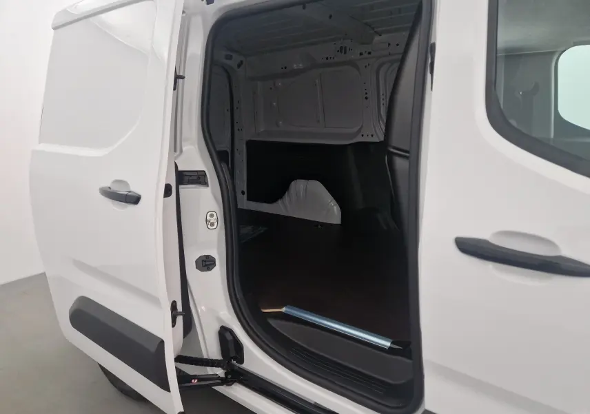 Vue latérale gauche du Peugeot Partner blanc 2025 avec porte coulissante ouverte dévoilant l'espace de chargement vide.