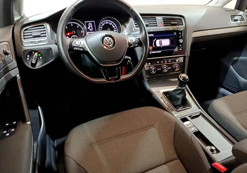 Vue intérieure avant de la Volkswagen Golf 1.6 TDI 2018, tableau de bord noir avec écran tactile et boîte manuelle.