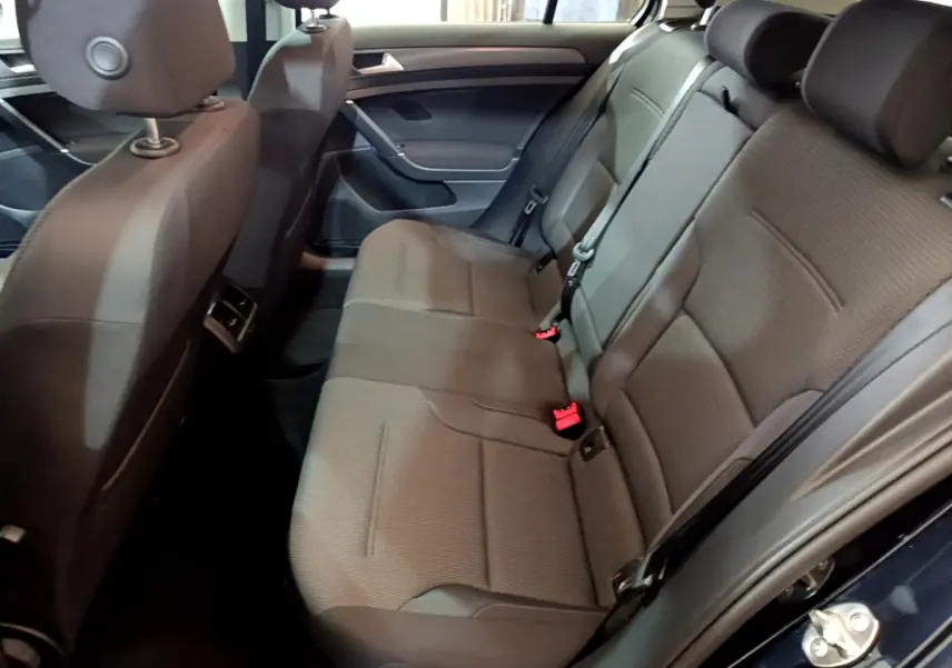 Vue intérieure côté droit des sièges arrière gris foncé d'une Volkswagen Golf noire de 2018, avec ceintures et appuie-têtes visibles.