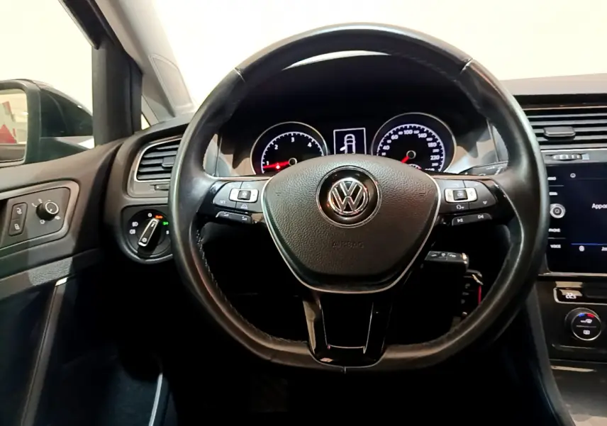 Vue intérieure centrée sur le volant cuir noir de la Volkswagen Golf 2018 avec tableau de bord et commandes visibles.
