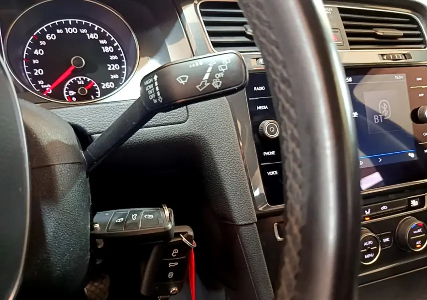 Vue intérieure rapprochée du tableau de bord et volant cuir noir d’une Volkswagen Golf 2018 avec écran tactile et commandes au volant.