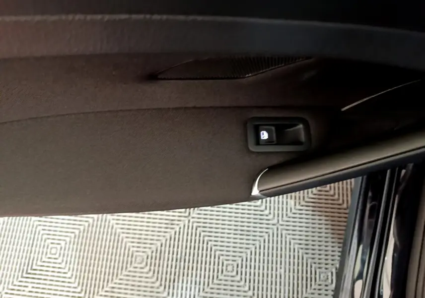 Détail de la poignée intérieure de porte côté conducteur d'une Volkswagen Golf noire, vue en plongée.