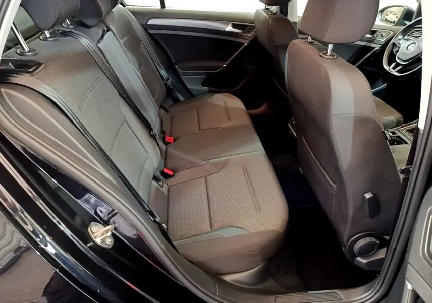 Vue intérieure côté gauche montrant la banquette arrière noire et les sièges avant d'une Volkswagen Golf 2018.