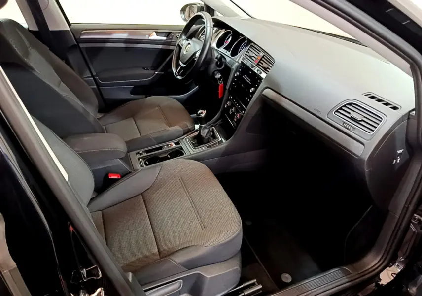 Intérieur noir de la Volkswagen Golf 2018, vue côté conducteur, avec tableau de bord et sièges tissu visibles.