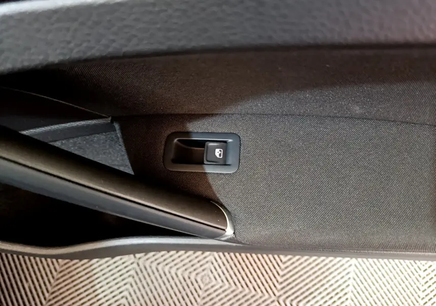 Détail de la commande d'ouverture du coffre sur la garniture intérieure noire d'une Volkswagen Golf 2018.