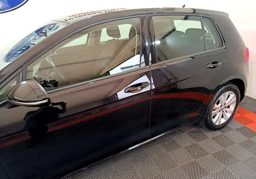 Vue latérale côté gauche d'une Volkswagen Golf noire 2018, mettant en valeur les vitres teintées et les jantes alliage.