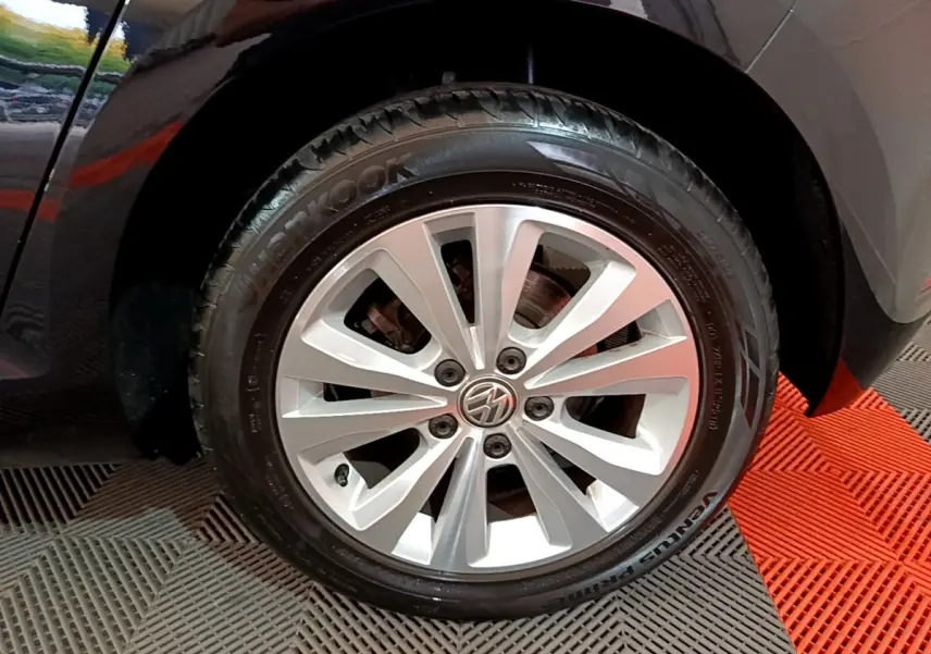 Gros plan sur la roue avant droite d'une Volkswagen Golf noire avec jante alliage argentée et pneu Hankook.