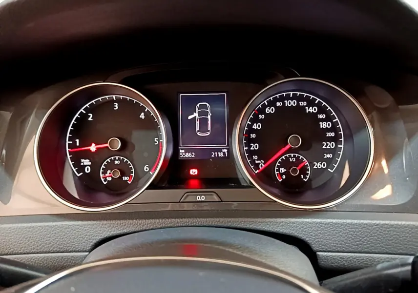 Vue rapprochée du tableau de bord de la Volkswagen Golf noire, affichant compte-tours, vitesse et écran multifonctions.