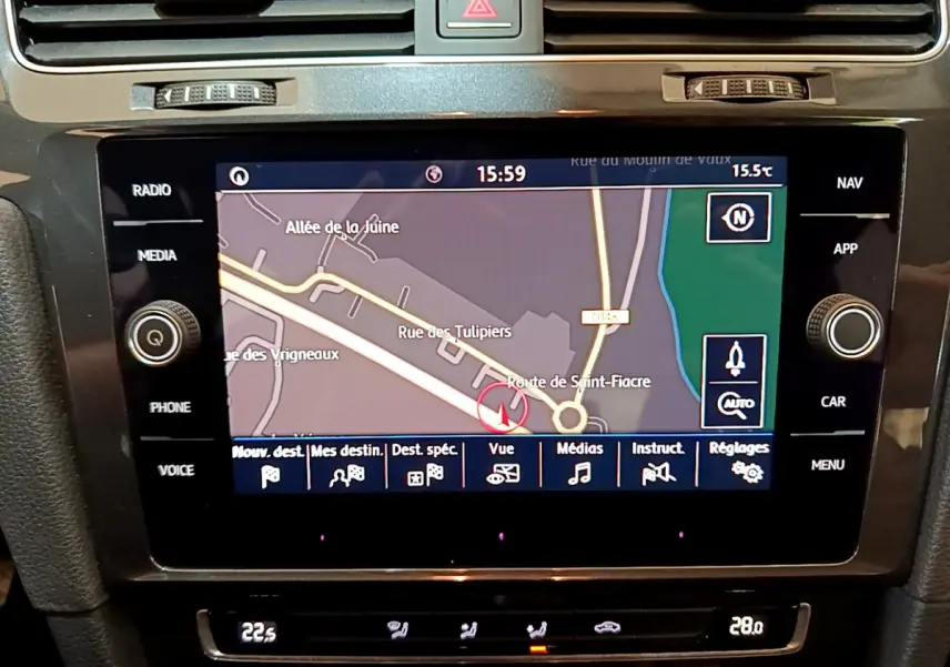 Vue rapprochée de l’écran tactile central de navigation d’une Volkswagen Golf noire, affichant une carte routière.