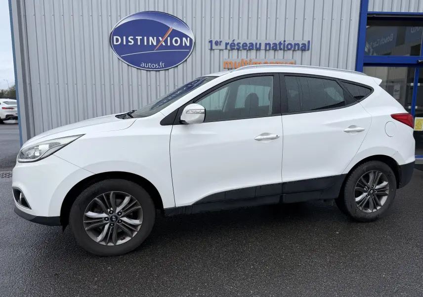 Vue de profil côté gauche d'un Hyundai ix35 blanc de 2014 avec jantes alliage et rétroviseurs blancs.
