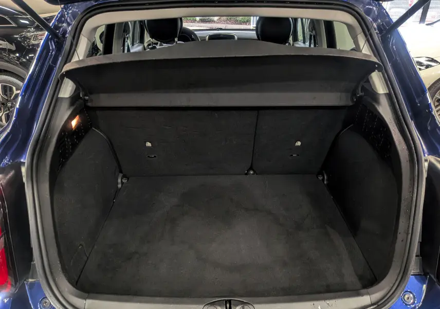 Coffre ouvert vu de l'arrière d'un FIAT 500X bleu Venezia 2024, montrant un espace de chargement propre et spacieux.