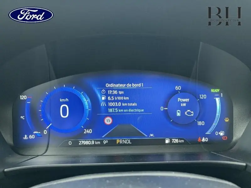 Tableau de bord numérique bleu du Ford Kuga 2023, affichant vitesse, consommation et autonomie électrique.