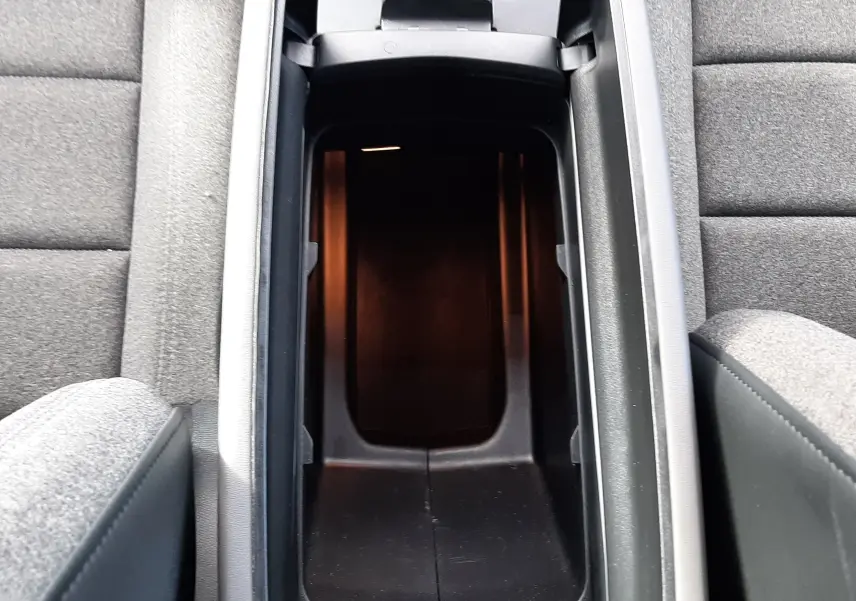 Vue plongeante sur le rangement central ouvert entre les sièges gris du Citroën C5 Aircross noir.