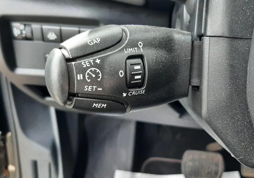 Gros plan sur la commande de régulateur de vitesse noire à gauche du volant d'un Citroën C5 Aircross 2020.