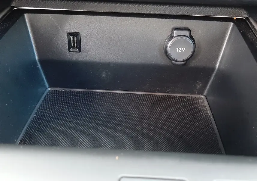 Gros plan sur la prise USB et l’allume-cigare 12V dans le rangement central du Citroën C5 Aircross noir.