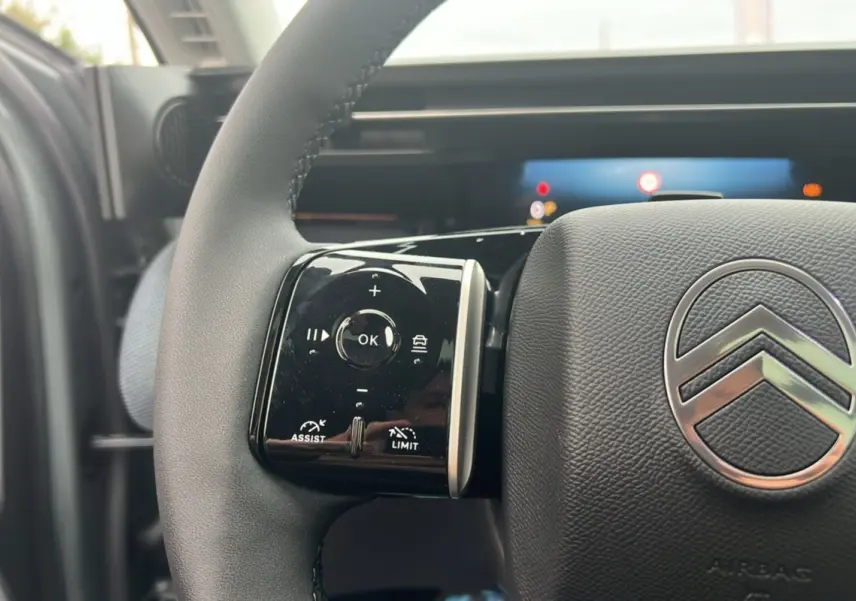 Gros plan sur le volant cuir multifonctions du Citroën C5 Aircross New Hybrid 145 Max T.O, logo chrome visible.