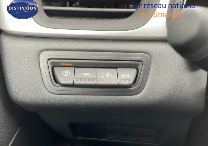 Gros plan sur les boutons de contrôle E-SAVE et ECO du tableau de bord d’une Renault Symbioz blanche nacrée.