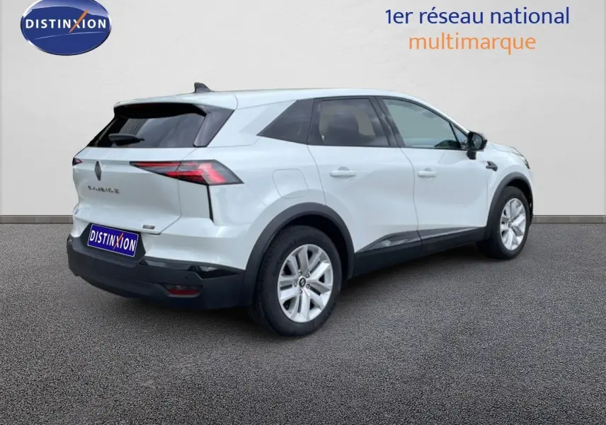 Vue 3/4 arrière droite d’un Renault Symbioz blanc nacré hybride avec jantes argentées et vitres teintées.