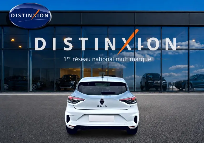 Vue arrière d'une Renault Clio V blanche 2025 stationnée devant une vitrine avec logo Distinxion.