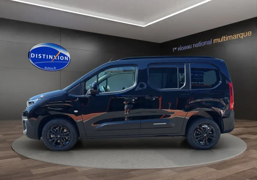 Profil latéral droit d'un Citroën Berlingo noir 2026 avec jantes noires, présenté en showroom intérieur.