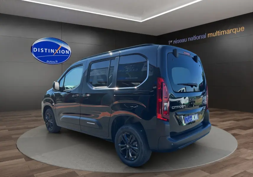 Vue 3/4 arrière droite du Citroën Berlingo noir 2026 avec vitres teintées et jantes foncées en showroom.