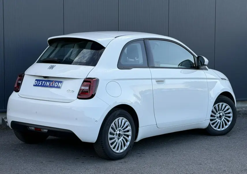 Vue 3/4 arrière droite d'une Fiat 500 électrique blanche Arctic avec jantes multibranches et feux arrière foncés.