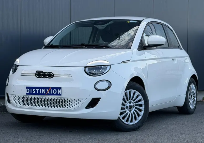 Vue 3/4 avant droite d'une Fiat 500 électrique blanche Arctic avec jantes multibranches et calandre épurée.