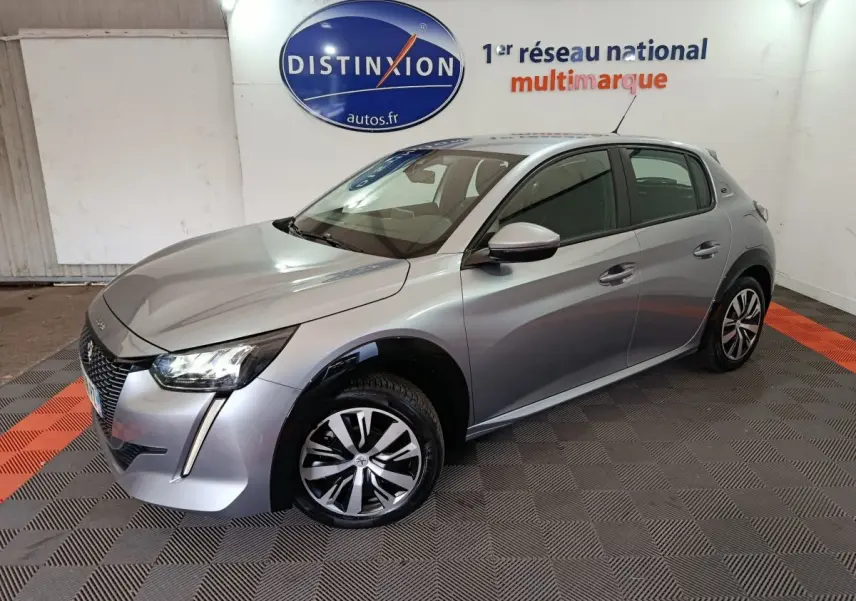Peugeot 208 électrique gris clair vue 3/4 avant droit, avec phares LED et jantes distinctives en concession.