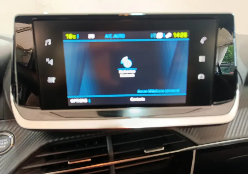 Écran tactile central 7 pouces du tableau de bord de la Peugeot 208 électrique gris clair, vue rapprochée intérieure.