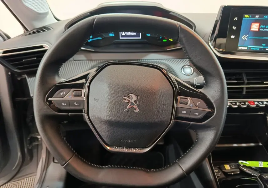 Volant cuir noir de Peugeot 208 électrique Active Business 2020, vue frontale avec tableau de bord digital et écran tactile visible.