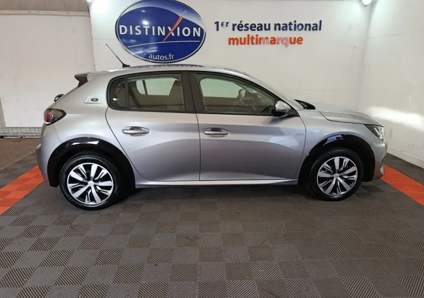 Profil côté gauche d'une Peugeot 208 électrique Active Business gris clair, avec jantes modernes et détails noirs contrastants.